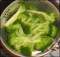 Broccoli is being steamed in a hot pot to serve with crock pot macaroni and cheese.