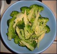 The steamed broccoli is topped with some of the cheese sauce from the crock pot.