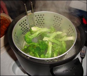 Cut up broccoli in the fryer/steamer basket over boiling water in our hot pot, being steamed.