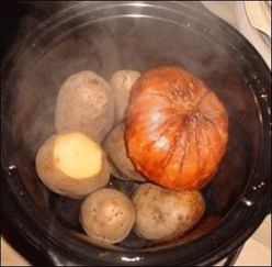 Clean whole vegetables were cooked in a crock pot with a slab of ham on top.