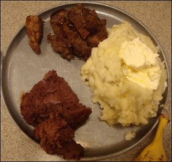 Mashed potatoes topped with butter shown with other food items from a truck stop restaurant buffet.