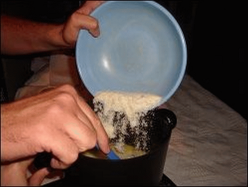 Mike prepares instant potatoes in a hot pot in his truck. Here he is adding the potato flakes into the mixture of hot water, salt, butter and milk.