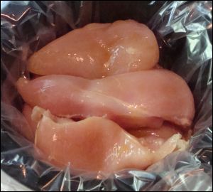 Boneless skinless chicken breasts in the slow cooker liner in the crock pot, ready to cook.