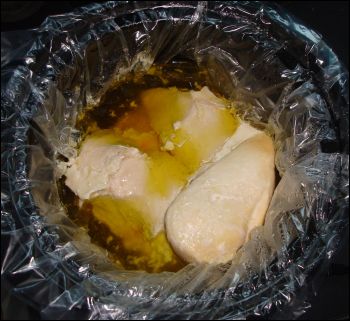 The cooked chicken breasts that have been prepared in a crock pot with chicken bouillon.