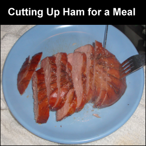 Cutting up ham for a meal.