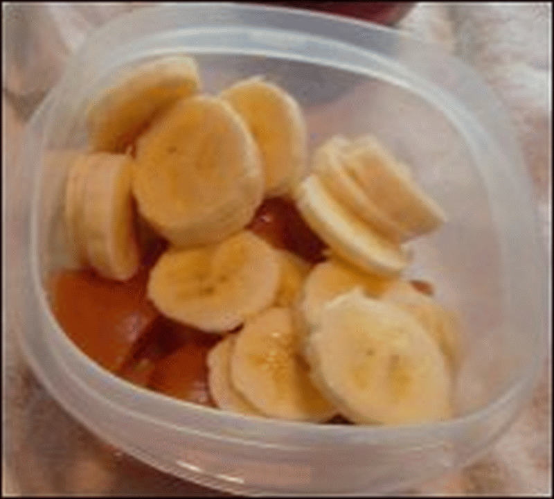 A sliced banana was the third layer of the fruit salad that Mike fixed.