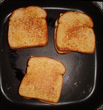 Grilled cheese sandwiches made in an electric skillet using 'square' wheat bread.