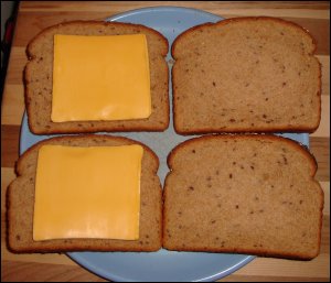 Preparing grilled cheese sandwiches on 'elongated' multi-grain bread. See how much room is left over on the edges of the bread from the square cheese slice.