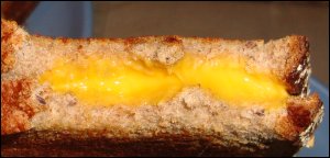 A close-up of the grilled cheese sandwich after a couple of bites have been taken. Notice how well the American cheese slices melted while the bread was browning.