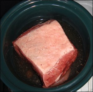 The prepared meat is placed in a slow cooker or crock pot with a 2:1 mixture of water and beef bouillon.