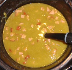 Crock pot of green split pea soup with ham.