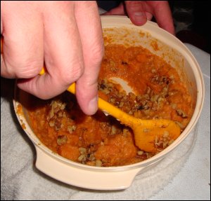 Mike mixes the cooked sweet potato flesh with margarine, brown sugar and walnut pieces.
