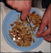 Mike cuts walnuts before adding them to his preparation of sweet potato casserole.