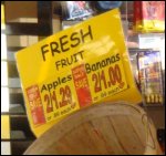 Fruit stand at truck stop, selling apples and bananas.