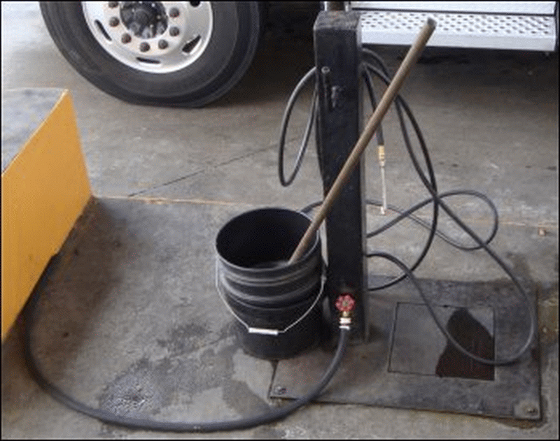 A photo taken out the passenger window at this facility of some of the amenities we look for at all truck stop fuel islands: treated windshield washing water, a long-handled squeegee with both sides in good condition, an air hose with commercial truck tire pressure, and a water spigot with a hose -- even though the hose in this case was too short.