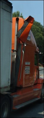 Damage to a truck tractor on passenger side air fairing near roof.