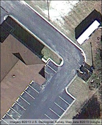 View of concrete curb over which trucks have rolled.