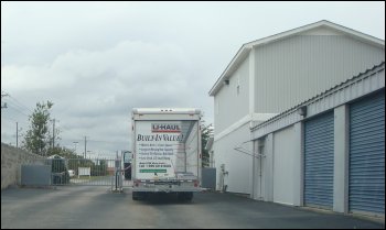 Mike Simons leans out of the U-Haul to punch in the security passcode to exit their self storage facility after moving their large belongings.