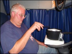Professional driver Mike Simons shows how the Presto Kitchen Kettle's steam/fry basket rests on the edge of the appliance.