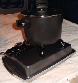 Side view of assembled Presto Kitchen Kettle sitting on a heat resistant surface, with electric cord attached.