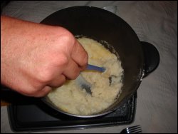 Overhead view of Mike stirring the potato flakes into the prepared liquid mixture.