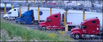 A photo of trucks parked in parking spots equipped with the anti-idling service modules.