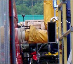 A view of the anti-idling control module connected to a window adapter in a truck's window.