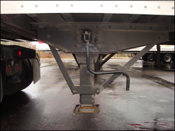 Although this semi trailer is connected to a tractor, this is the correct position of the landing gear crank handle behind a fixed hook.