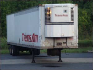 A dropped refrigerated van at a receiver, left with its landing gear sticking out.