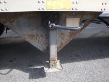 Although this semi trailer is connected to a tractor, this is the correct position of the landing gear crank handle behind a movable hook.