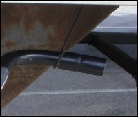 A close-up view of a landing gear crank handle, tucked into place behind a movable hook on a trailer.