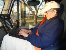 Vicki using a laptop computer in Mike's truck