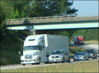 Trucks on a road where the bridges are high enough to pass under without problems.