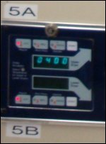 The close-up of the panel on stacked dryers in a laundromat, which shows 4 minutes of drying time left on the top dryer.