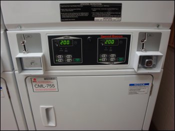 The panel from a set of stacked dryers in a truckstop, showing the coin slots, temperature settings and which slots and settings go with which dryer.