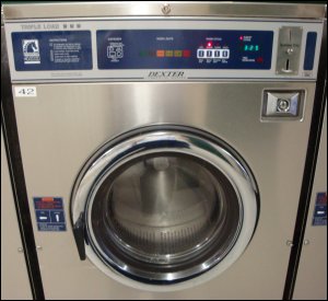 A Dexter Triple Load washing machine, which requires 13 quarters to operate.