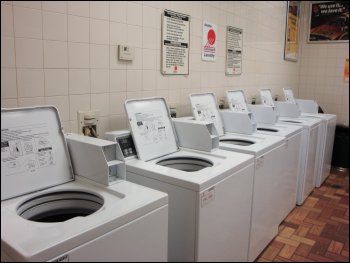 A row of coin-operated washing machines in a truckstop laundromat.
