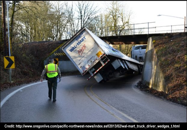 A truck driver gets his 13 foot 6 inch truck stuck under a 12 foot 9 inch bridge.