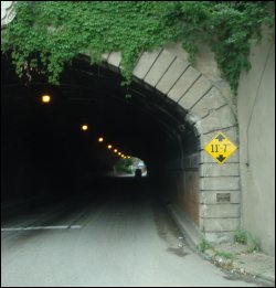 A well marked low clearance sign on a bridge overpass.