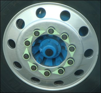Lug nut torque indicators or loose wheel nut indicators installed on the lug nuts of a steer tire of a commercial motor vehicle.