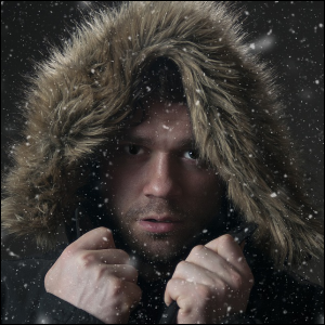 Man wearing heavy coat with fur in cold winter weather.