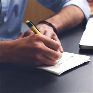 Man writing, planning on paper.