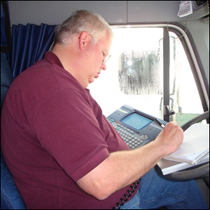 Mike Simons writing info from a QualComm unit while resting on an aluminum forms holder.