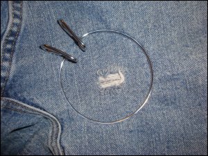 The original hole in the jeans that needed patching, held taut by an embroidery hoop.