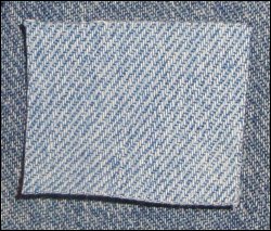 Close up of patch sized to cover hole in jeans needing a patch.