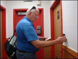 With polarized sun glasses on his head, professional truck driver Mike Simons enters the code to gain access to a truck stop shower.