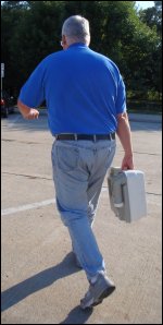 Mike takes the waste holding tank from his portable toilet to a restroom to dump the contents.