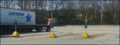 A distance photo of 3 spaces designated as reserved parking for trucks.