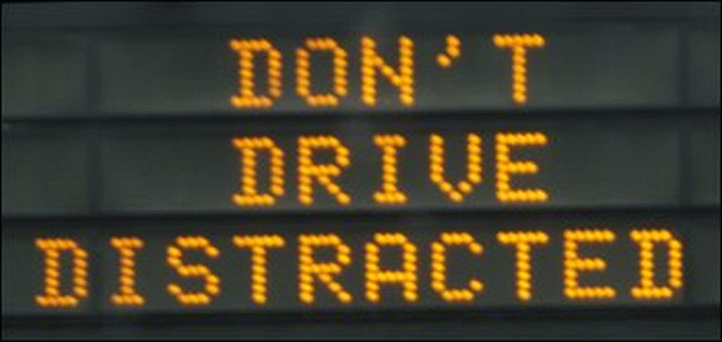 Road sign proclaming: Don't Drive Distracted.