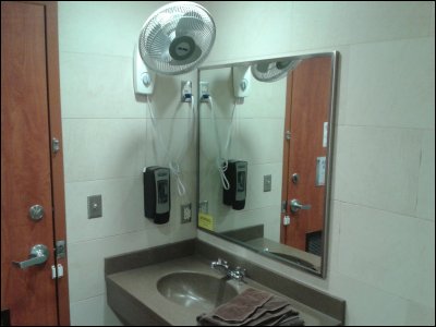 View of sink, mirror, fan, soap dispenser, towels and door lock in shower facility at Flying J in Hudson (Roberts) Wisconsin